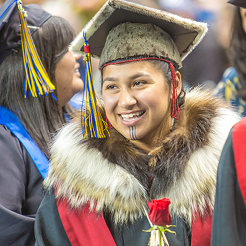 UAF student smiles in graduation gown