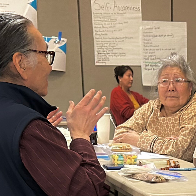 Two elder teachers talking during lunch break.