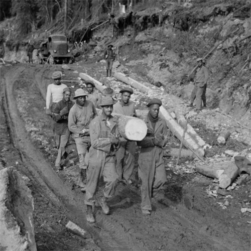 Black soldiers work together to haul logs down a cleared section of the road while building Alaska Highway Black soldiers who helped construct the Alcan, like these men hauling logs down a cleared section of road, are often considered instrumental in the integration of the U.S. Army. U.S. Army Photo courtesy of Office of History, HQ, U.S. Army Corps of Engineers.