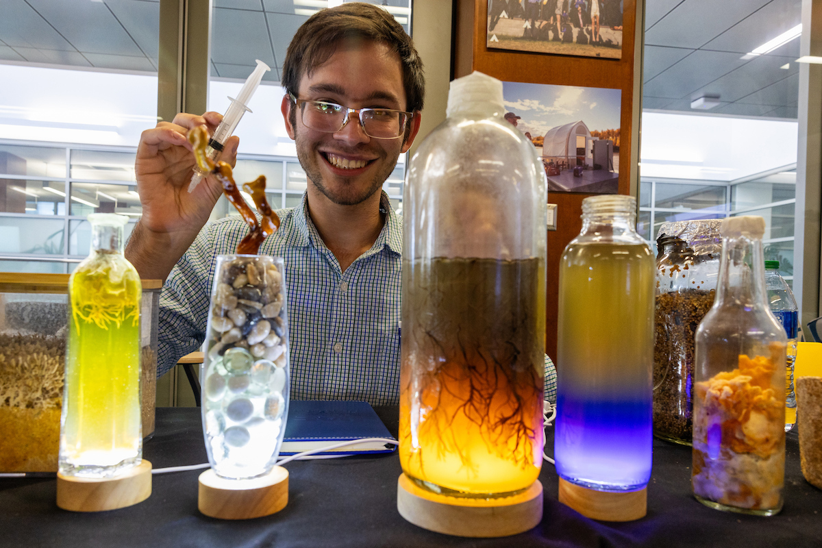 The illuminated mycology display at Andrew Forbes's table at the Alaska Center ICE and URSA Research Showcase as attendees enjoy a variety of activities during the 2024 Nanook Rendezvous UAF Alumni Reunion Campus Day Friday, July 19, 2024. UAF Photo by Eric Engman
