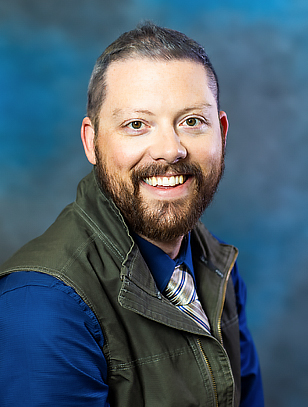 Headshot photo of Bryan Uher smiling