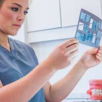 woman looking at dental x-rays