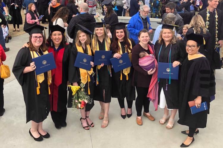 Support Social Work Scholarships Social Work graduates pose with their diplomas after the commencement ceremony.